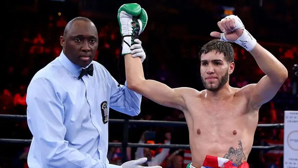 Prichard Colon has his arm raised by a referee in a boxing ring