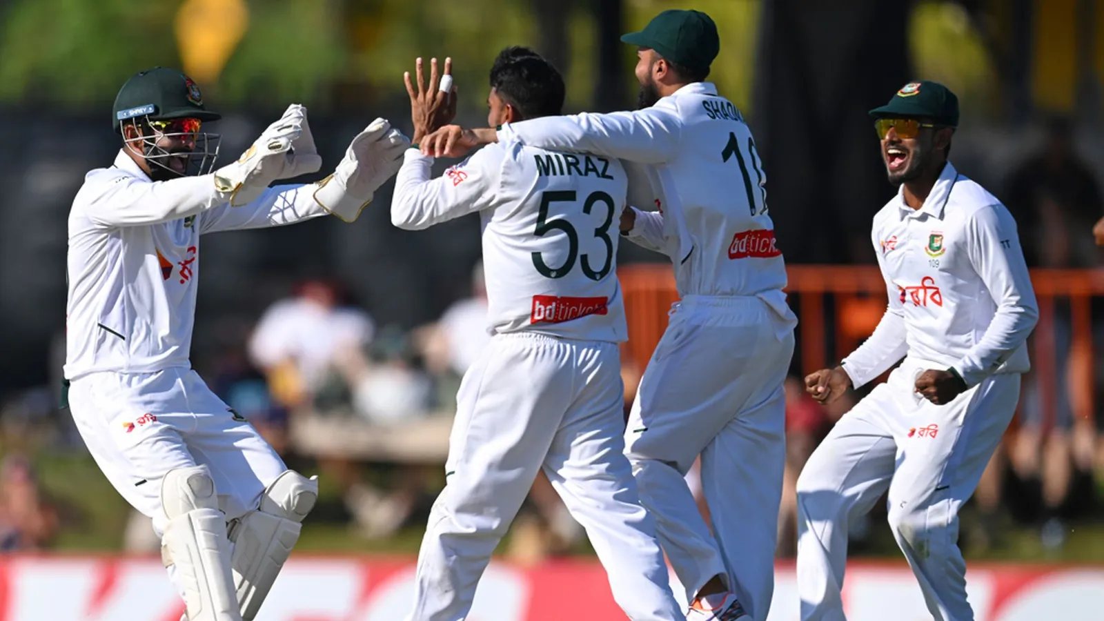Bangladesh's Mehidy Hasan Miraz, centre, is congratulated by team-mates after his caught and bowled dismissed Steve Smith